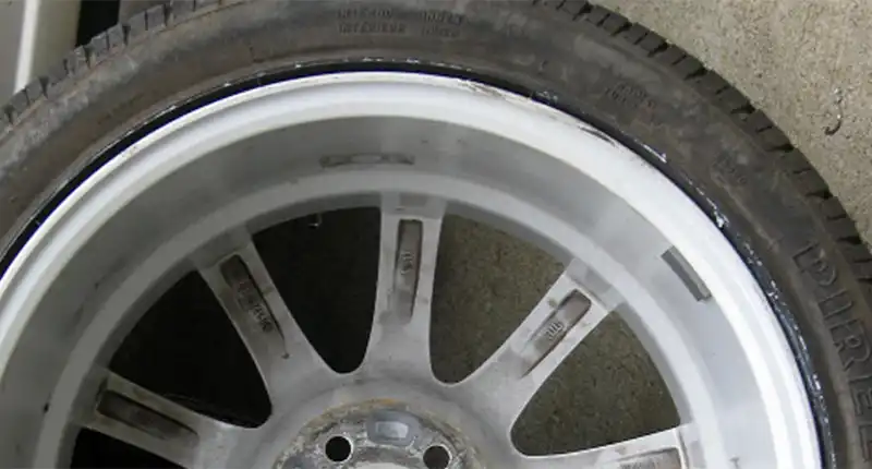 Closeup of a misaligned alloy wheel after a repair.
