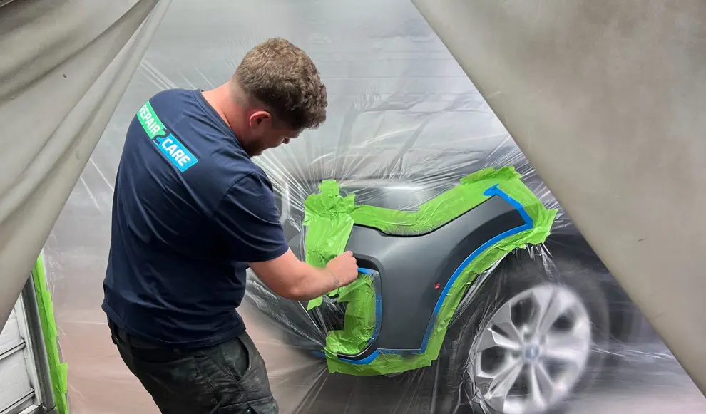 Repair2care tekniker gör en lackreparation på den främre stötfångaren på en bil