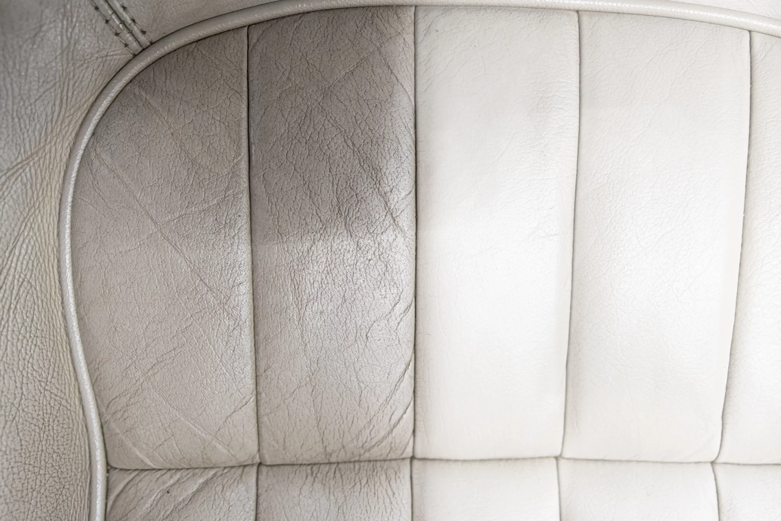 Before and after picture of a discolored white leather car seat.