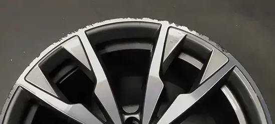Closeup of a damaged diamond cut alloy wheel before a repair.