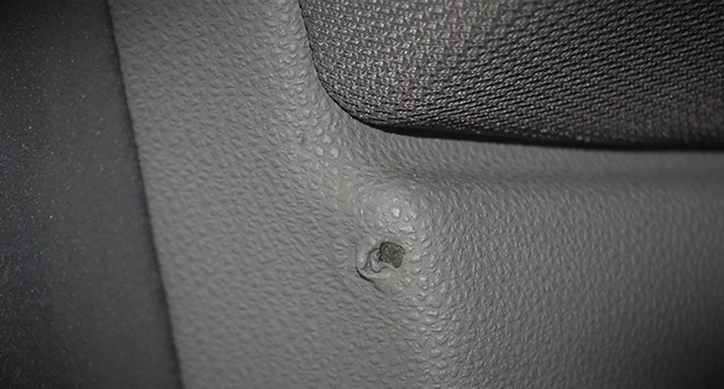 Before image of a vinyl repair on grey car interior