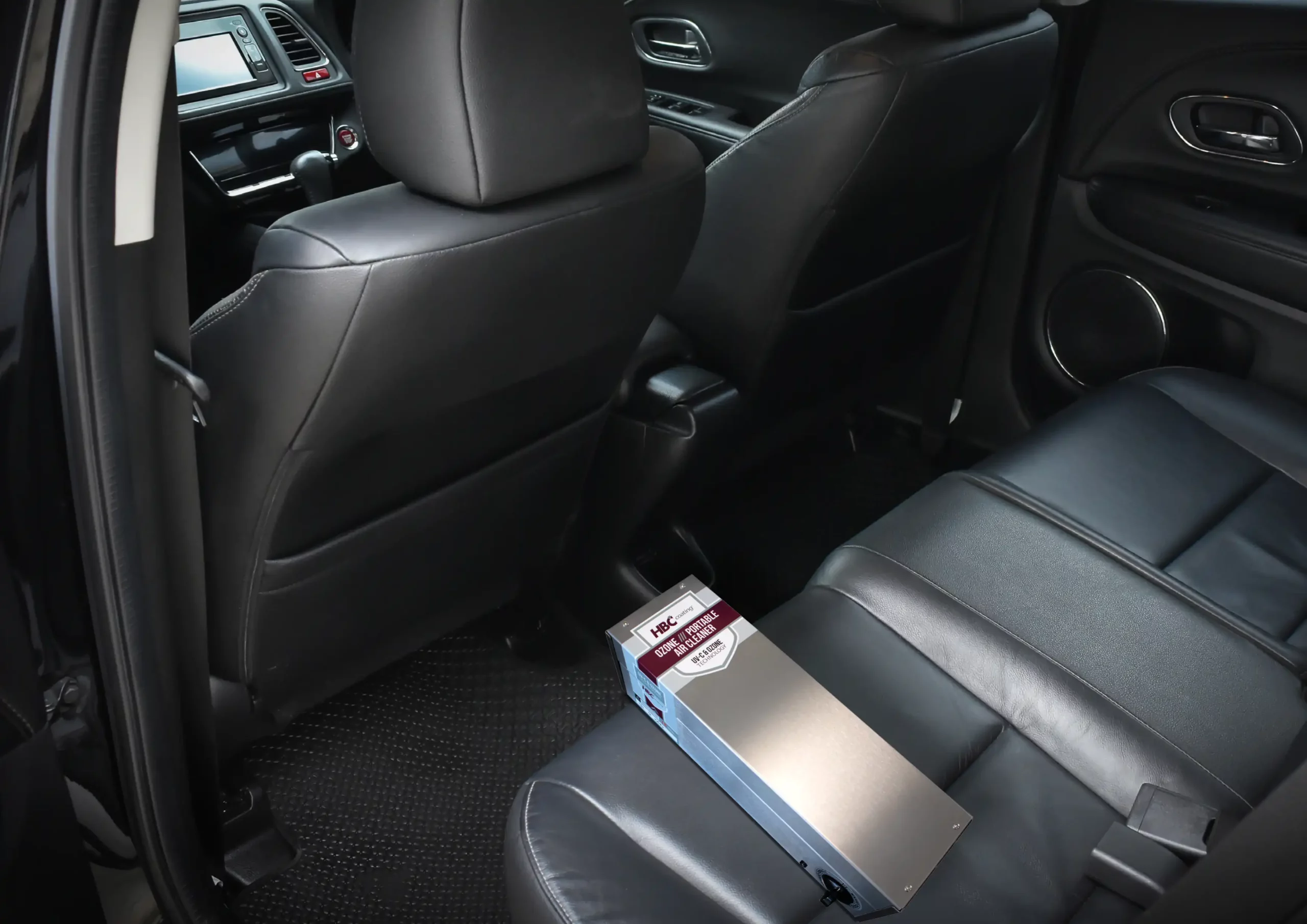 The HBC ozone air cleaner lays on the backseats in the car cabin.
