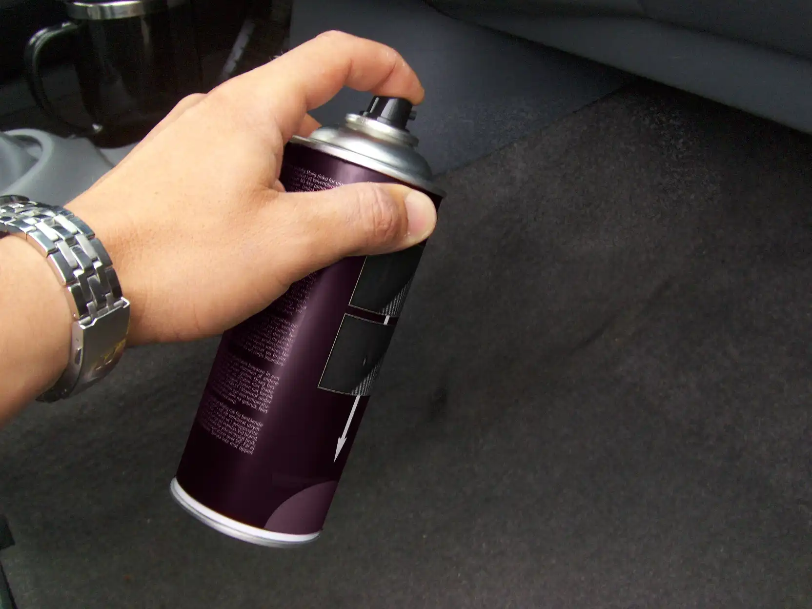 A technician removing discoloration on car carpet.