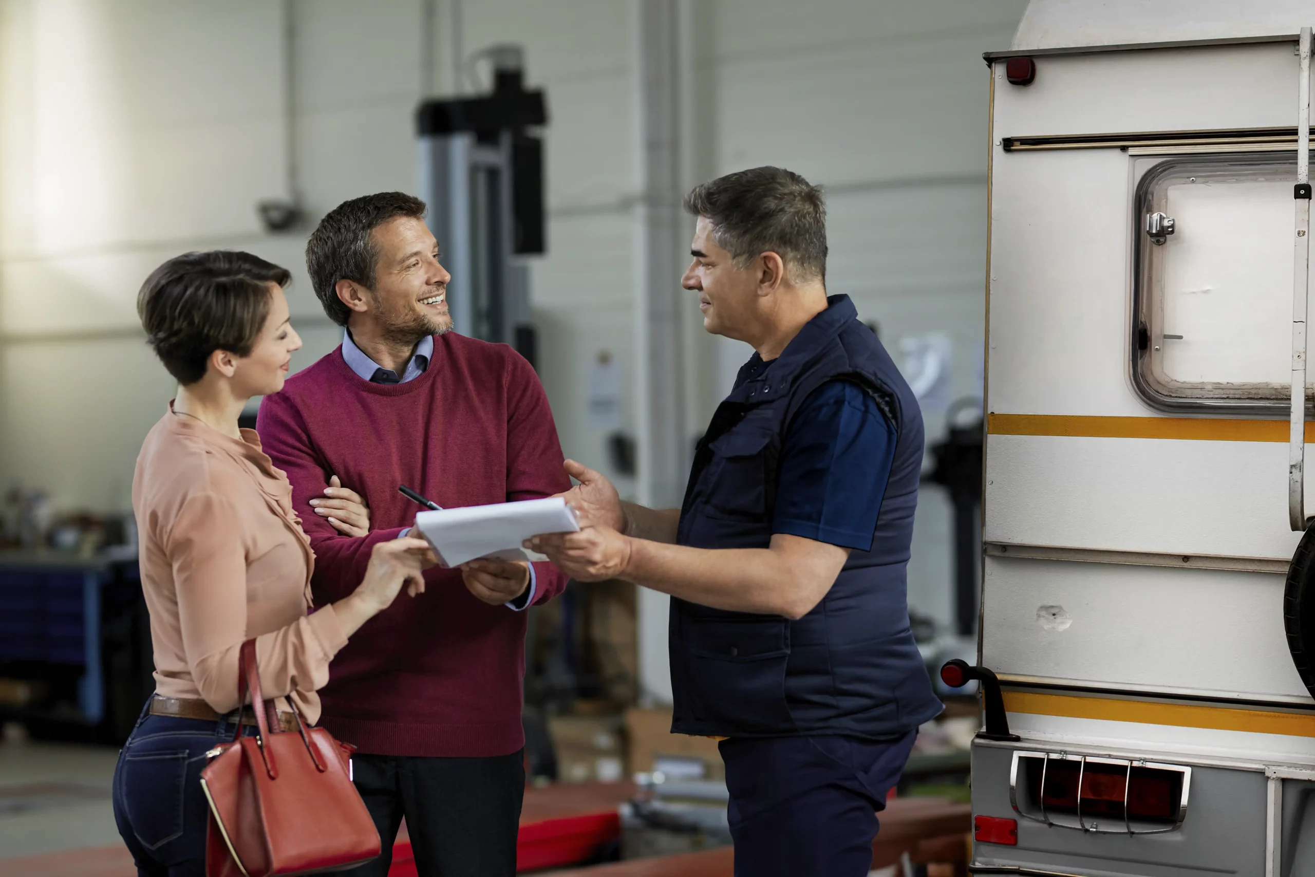 A couple talking to a Repair2Care technician about a caravan dent damage.