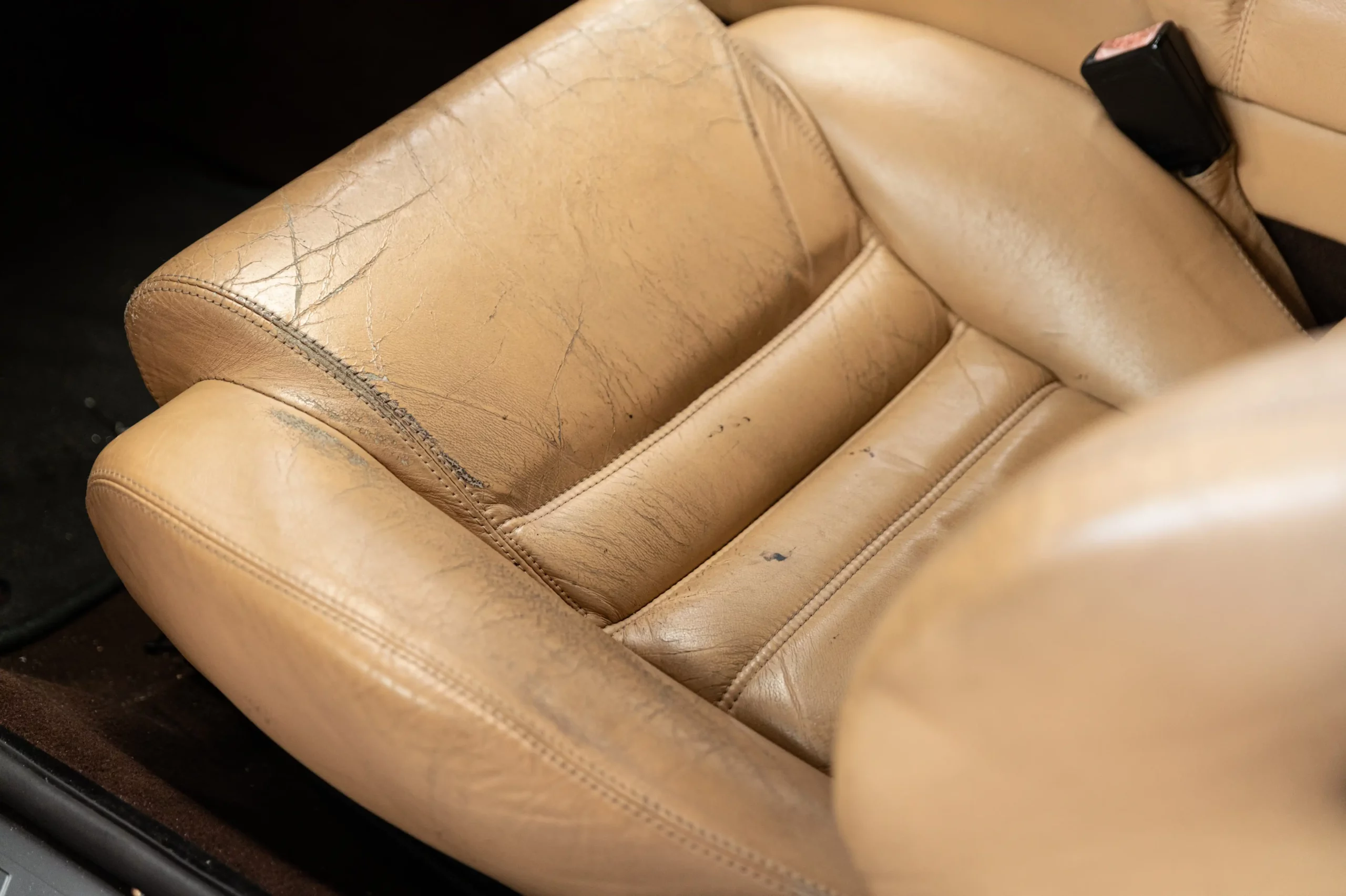 Cracked leather car seat in brown genuine leather.
