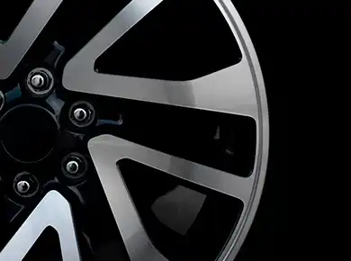 Closeup of diamond cut alloy wheel with shiny aluminium and black colored details.