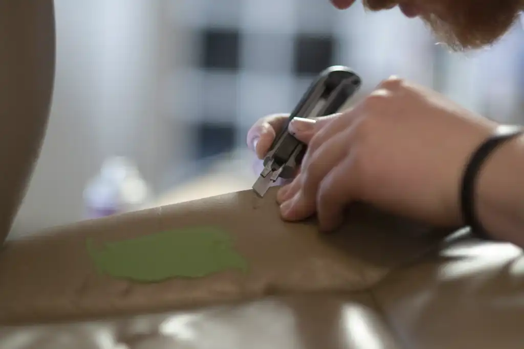 A technician reparing a hole in a leather car seat.