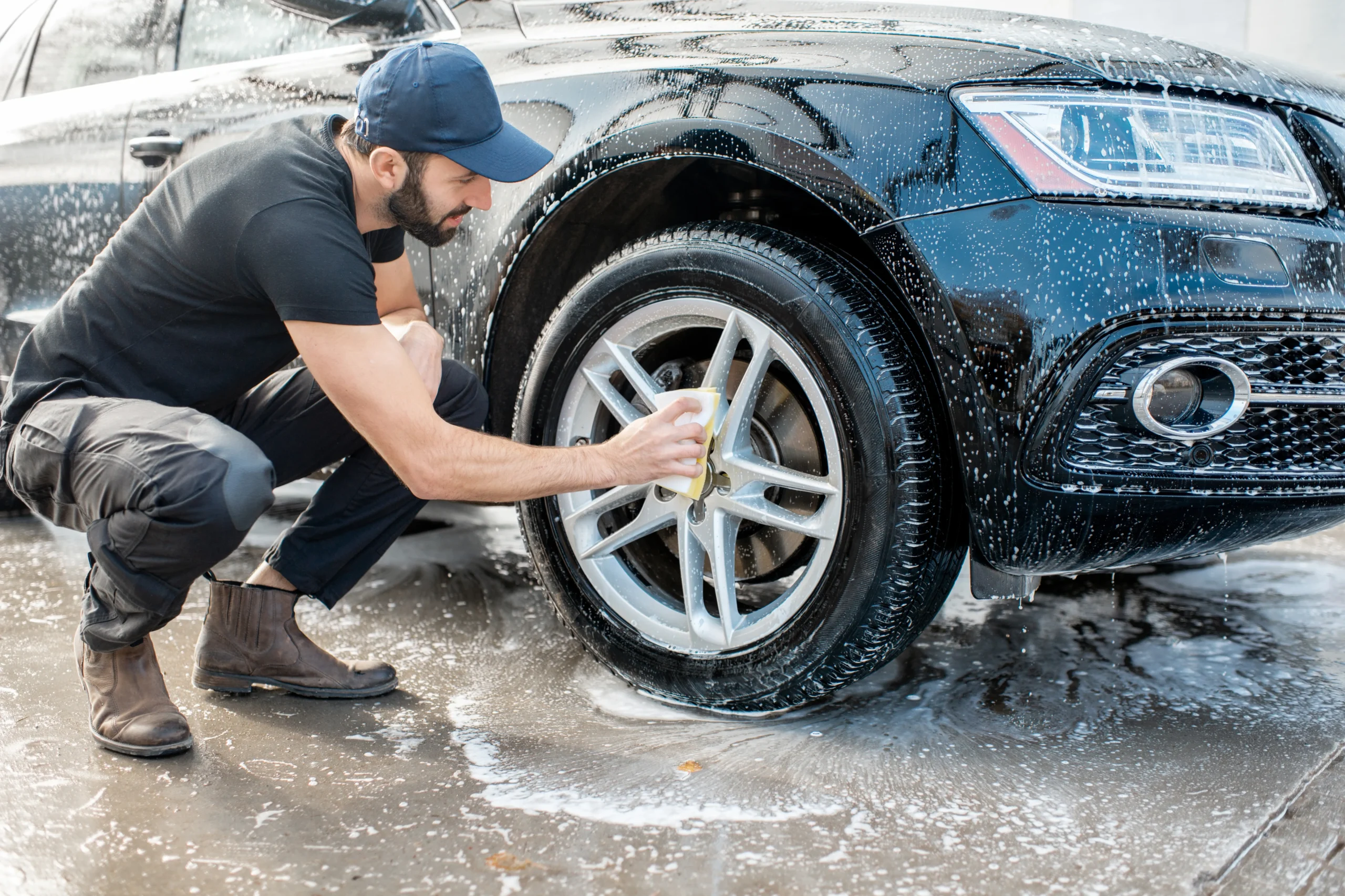 Professional washing a wheel on a vehicle