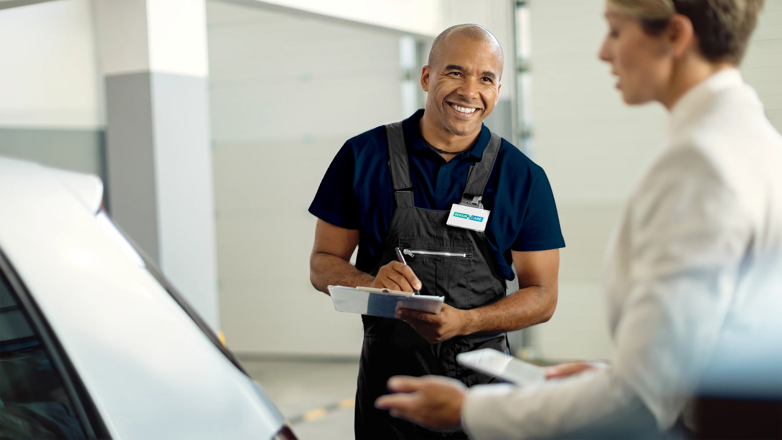 Repair2Care technician talking to a customer about paint repair on the back bumper.
