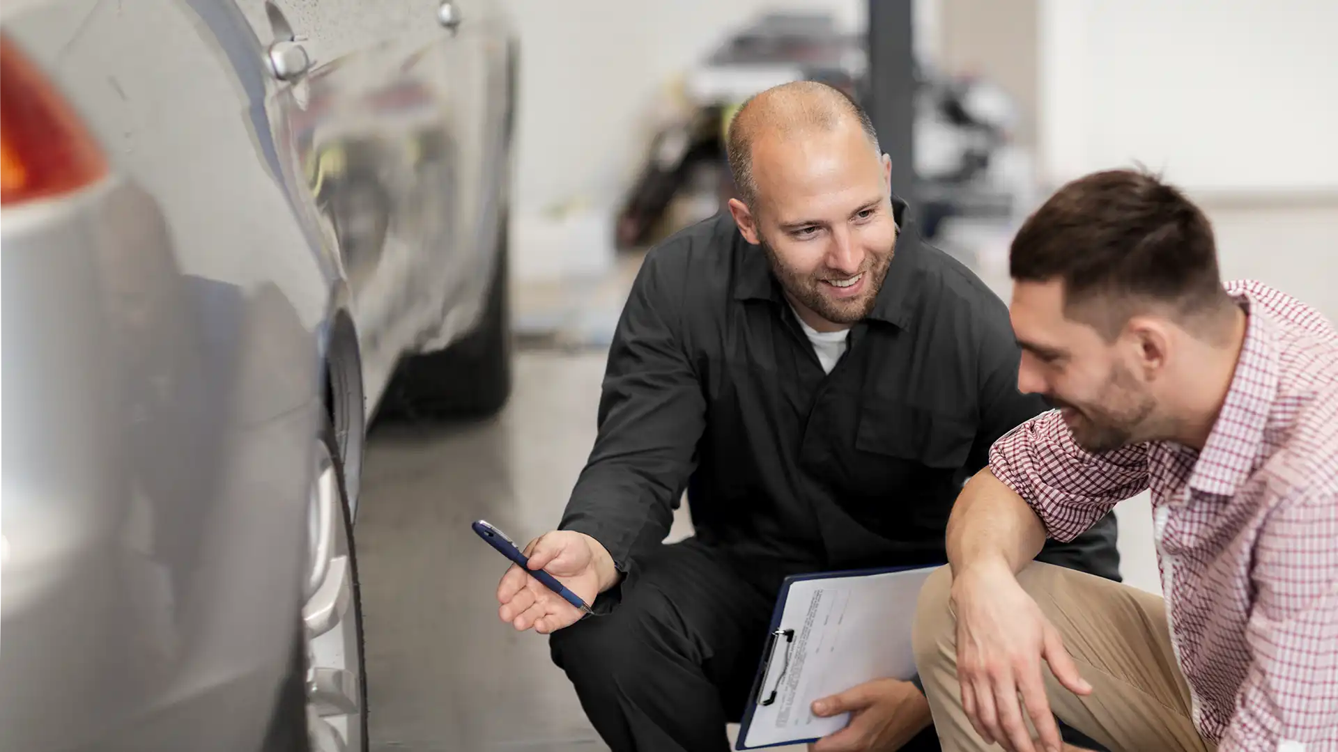 Repair2Care-Techniker im Gespräch mit einem Kunden über die Schäden an der Außenhaut des Autos.