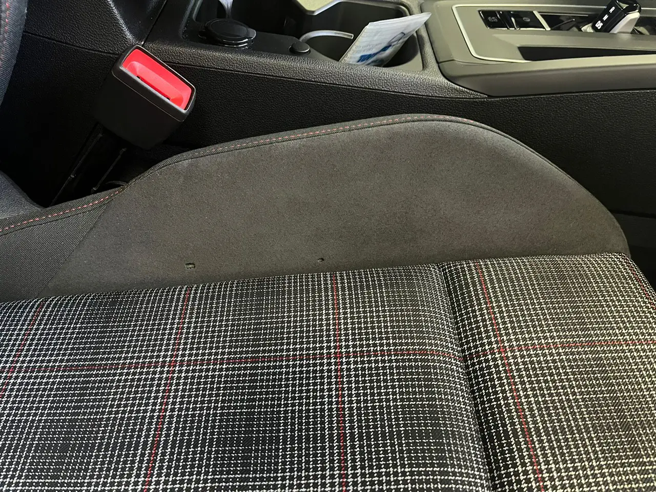 Två små hål i en bilbarnstol av tyg som är redo för reparation