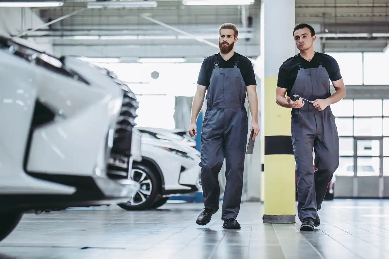 Two technicians walking in a car workshop.