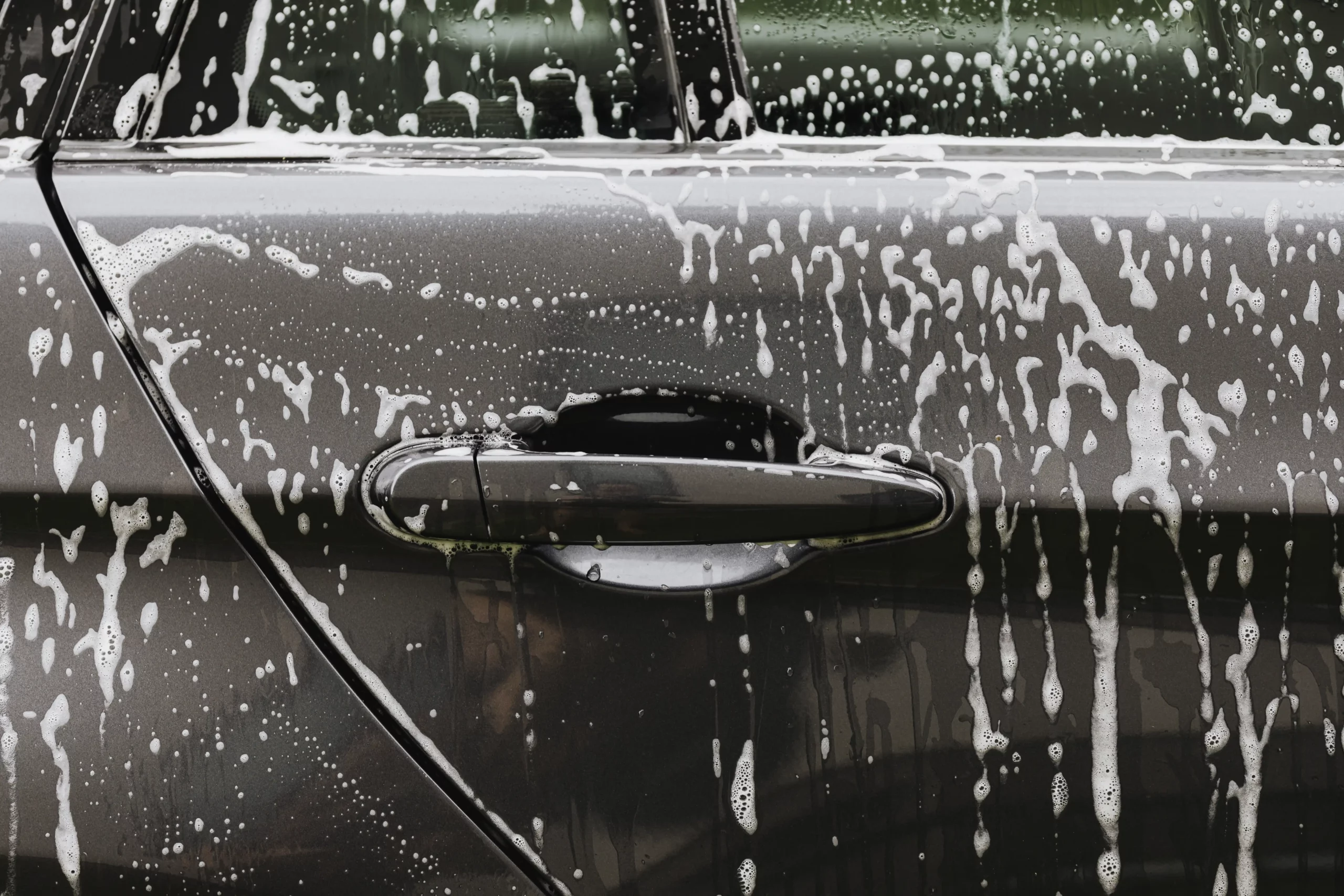 Closeup of a car covered in soap.