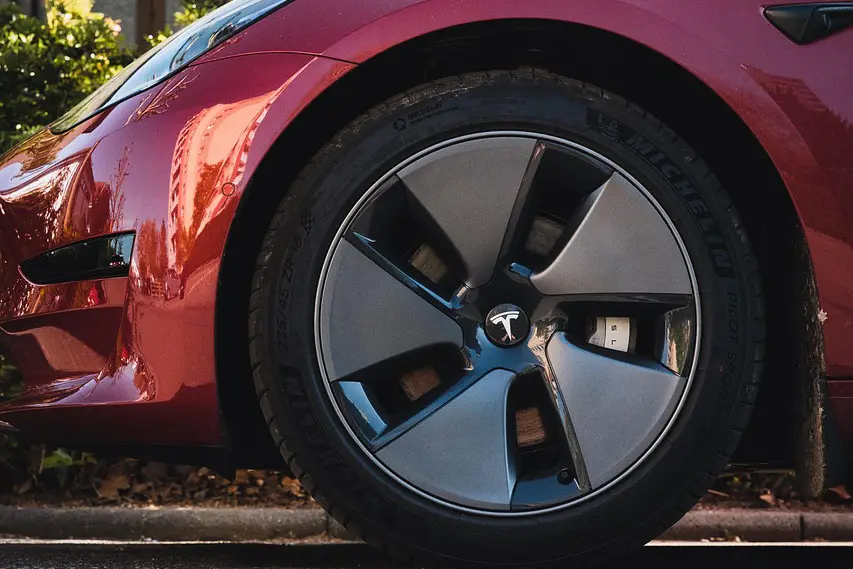 لقطة مقربة للعجلة المعدنية على سيارة تسلا حمراء اللون